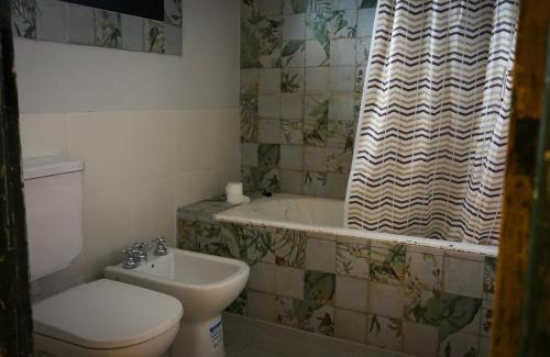 a bathroom with a toilet and a tub and a sink at Chaparisco in Puerto Madryn