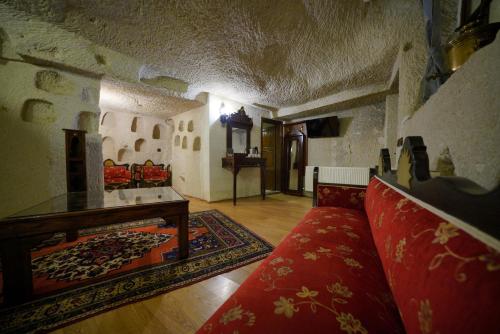a living room with a red couch and a table at Asteria Cave Hotel in Goreme