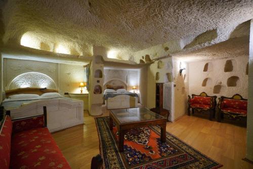 a living room with two beds and a table at Asteria Cave Hotel in Goreme