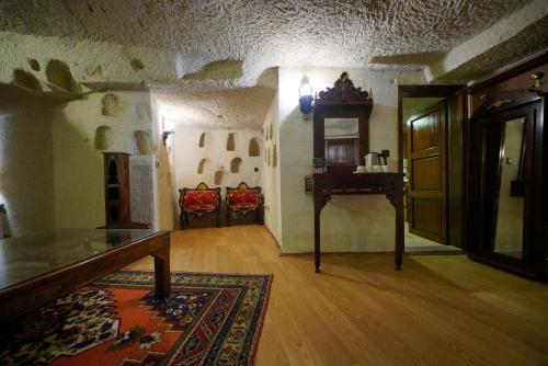 a room with a table and a desk in a house at Asteria Cave Hotel in Goreme