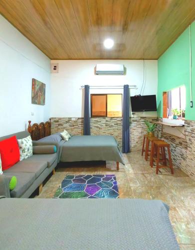 a living room with a couch and a tv at Casa Victoria in Puntarenas
