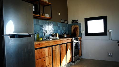 a kitchen with a refrigerator and a stove top oven at Chaparisco in Puerto Madryn