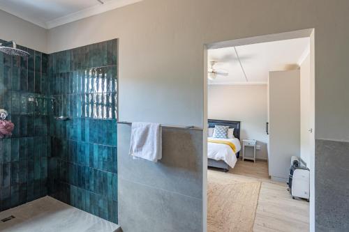a bathroom with a glass shower and a bed at Tevrede in Middelplaas