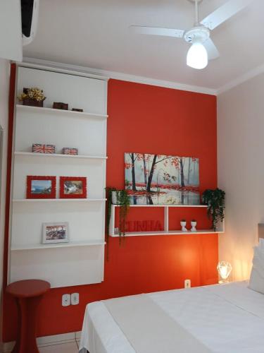 a bedroom with red walls and a white bed at Hospedagem Quarto Chic centro Cunha in Cunha