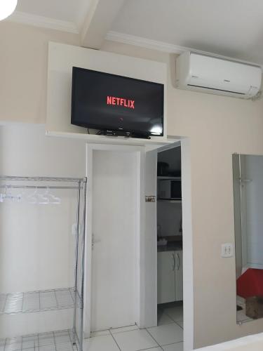 a flat screen tv on top of a wall at Hospedagem Quarto Chic centro Cunha in Cunha