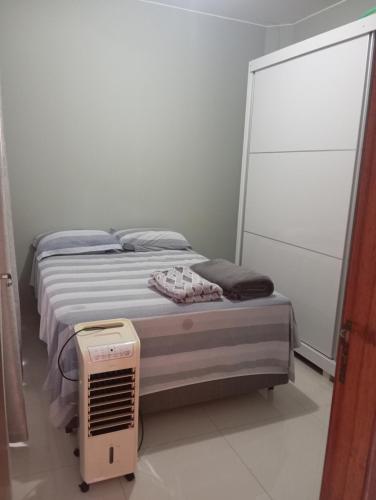 a small bedroom with a bed with a fan at Casa Completa in Cascavel