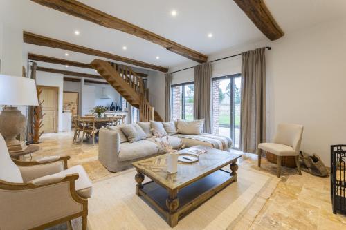 un salon avec un canapé et une table dans l'établissement Maison Melrose Lovely house near Deauville, à Cricquebœuf