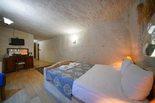 a bedroom with a bed in a stone wall at Asteria Cave Hotel in Goreme