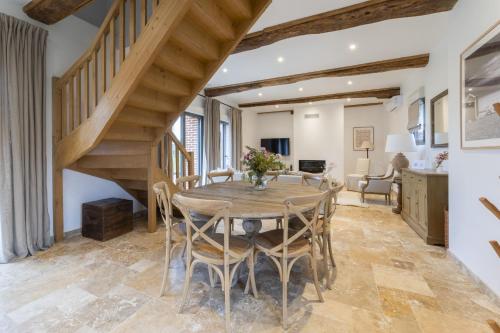 une salle à manger avec une table en bois et un escalier dans l'établissement Maison Melrose Lovely house near Deauville, à Cricquebœuf