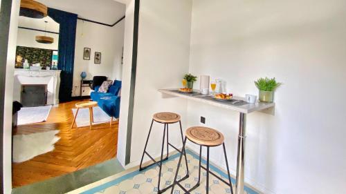 - une cuisine et un salon avec un comptoir et des tabourets dans l'établissement VOYAGE AU CALME à 10 Minutes du centre avec PARKING INCLUS et FIBRE, IDÉAL SOLO et PRO, à Rouen