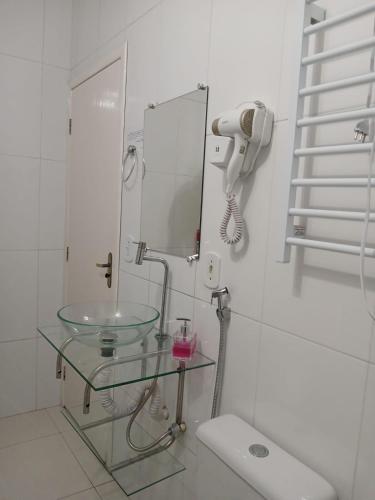 a bathroom with a glass sink and a mirror at Hospedagem Quarto Chic centro Cunha in Cunha