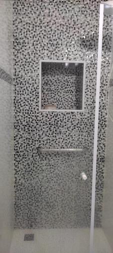 a shower with a glass door in a bathroom at Hospedagem Quarto Chic centro Cunha in Cunha