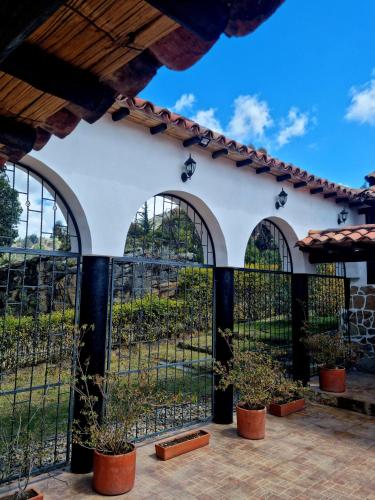a fence in a courtyard with potted plants at La Casona Cucaita. Sede Campestre in Cucaita