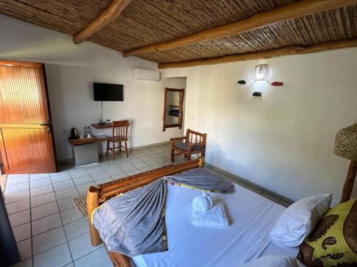 a bedroom with a bed and a living room at Telvina Beach Lodge in Vilanculos