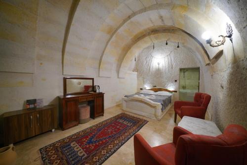 a bedroom with a bed and a couch and chairs at Asteria Cave Hotel in Goreme