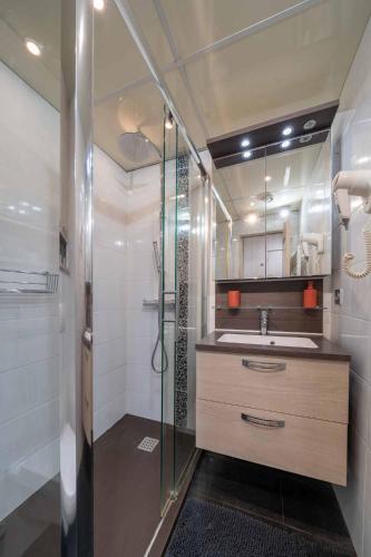 une salle de bain avec une douche, un lavabo et un miroir dans l'établissement Ciel d Azur avec terrasse en plein centre près de la Croisette, à Cannes