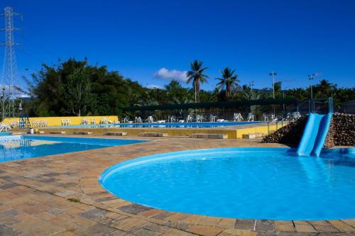 two swimming pools with a water fountain in the middle at Ilha Morena Praia Hotel by Concavus in Caraguatatuba