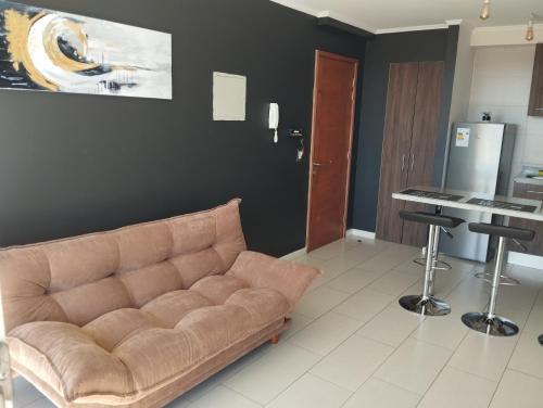 a living room with a couch and a table at Departamento 1 dormitorio, 1 cama doble, con balcón y estacionamiento in Temuco