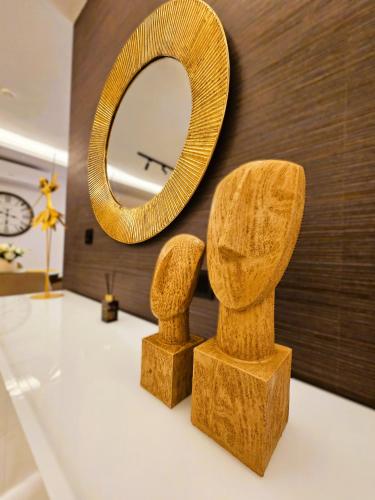 a mirror and two wooden statues on a table at Delmar Coastal Retreat in St. Paul's Bay