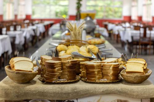 a table with bread and baskets of food on it at Ilha Morena Praia Hotel by Concavus in Caraguatatuba