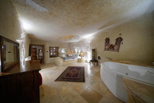 a bathroom with a tub and a living room at Asteria Cave Hotel in Goreme