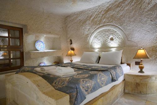 a bedroom with a bed in a stone room at Asteria Cave Hotel in Goreme