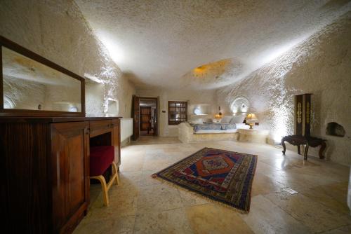 a living room with a bed and a table and a mirror at Asteria Cave Hotel in Goreme
