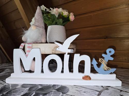 una señal para un puerto deportivo con un jarrón de flores en Haus Blume, en Carolinensiel