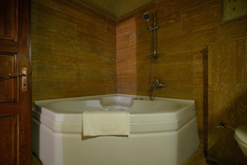 a bath tub in a bathroom with a sink at Asteria Cave Hotel in Goreme