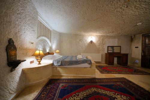 a bedroom with a bed and a lamp in a room at Asteria Cave Hotel in Goreme