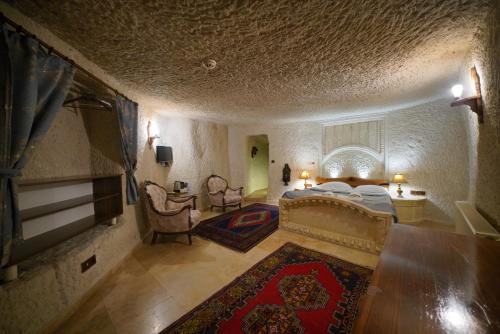 a bedroom with a large bed and a living room at Asteria Cave Hotel in Goreme