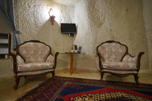 two chairs in a room with a table and a tv at Asteria Cave Hotel in Goreme