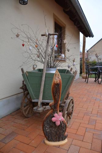 a statue of a cat pulling a green wheelbarrow at Ferienappartements "Landromantik" in Bautzen