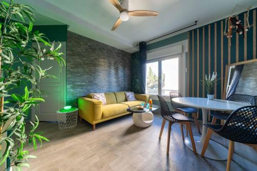 un salon avec un canapé jaune et une table dans l'établissement La jungle, centre ville, videoprojecteur, proche gare et commerce, 150m de la mer, à Vallauris