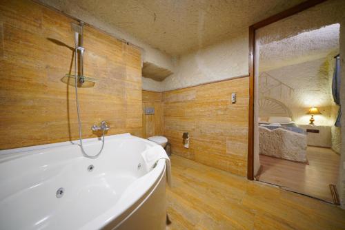 a large bathroom with a tub and a toilet at Asteria Cave Hotel in Goreme