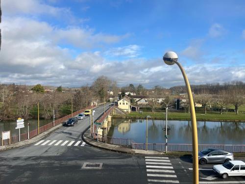 a street with a street light next to a body of water at Le Terrier in Mussidan