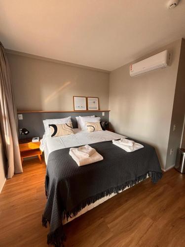 a bedroom with a large bed with two towels on it at Flat Premiun Vila Madalena in São Paulo