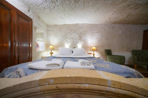 a bedroom with a bed with two towels on it at Asteria Cave Hotel in Goreme