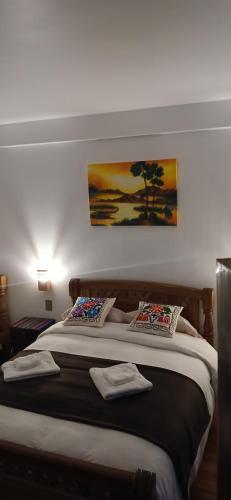 a bedroom with a large bed with two pillows at Puerto Yumani in Comunidad Yumani