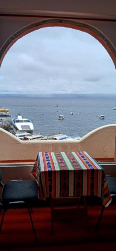 a table in a room with a view of the ocean at Puerto Yumani in Comunidad Yumani