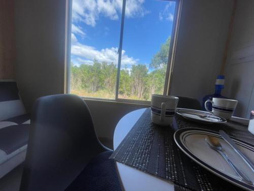 a table and chairs with a table and a window at Cabañas Aurora in Quilquico