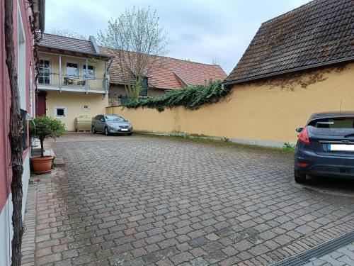 a street with two cars parked next to a building at Weingut Weinstube Weinhotel Wolf in Harxheim