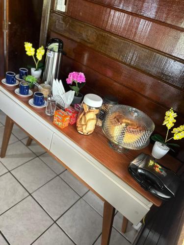 a table with food and other items on it at Pousada das Flores in Fernando de Noronha