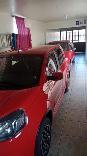two red cars are parked in a garage at Host Family S in São Gabriel