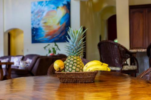 a basket of pineapple and bananas on a table at Cabarete Oceanview Villa Pool Oasis Beach Access in Cafemba