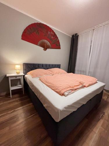 ein Schlafzimmer mit einem Bett, über dem ein roter Ventilator hängt in der Unterkunft Altstadt Apartments - Wohnen im Herzen der Stadt in Koblenz