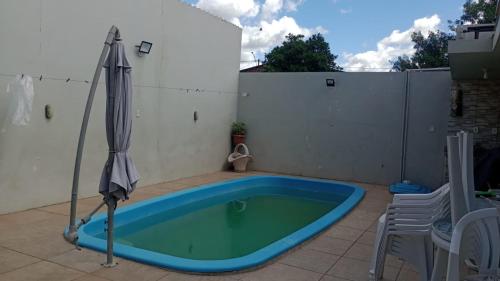 a swimming pool with an umbrella on a patio at Host Family S in São Gabriel