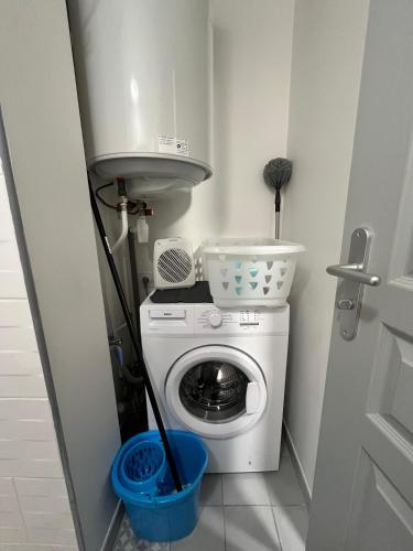 a small laundry room with a washing machine and a sink at Le Terrier in Mussidan