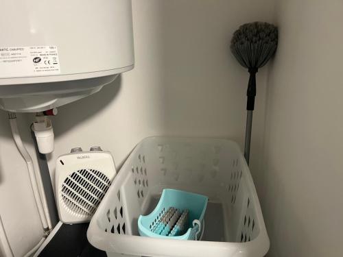 a white laundry basket with a brush in it at Le Terrier in Mussidan
