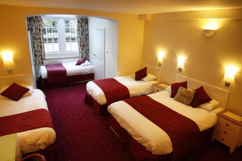 ロンドンにあるサネット ホテルのベッド3台と窓が備わるホテルルームです。